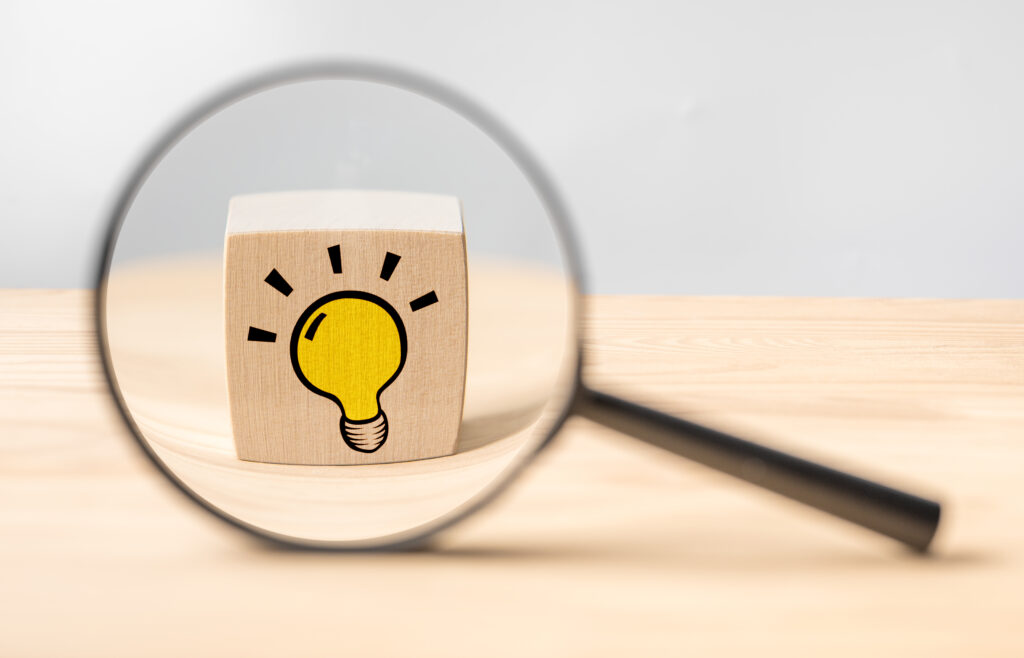 Magnifying glass with light bulb icon